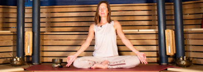 Frau im Schneidersitz bei einer Meditation in der Alhambra Sauna